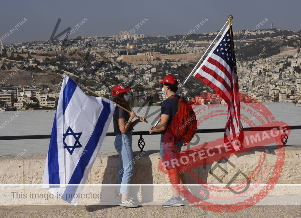 Israeli supporters of U.S. President Donald Trump hold Israeli and American flags during a Trump campaign rally in Jerus